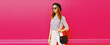 Leinwandbild Motiv Portrait of beautiful woman model wearing summer hat, white striped shirt, handbag on pink background