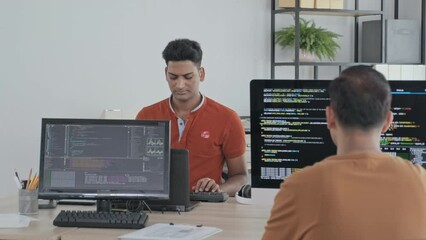 Wall Mural - waist up slowmo of indian programmers typing program codes on computers in it office