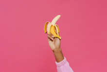 Black Man's Hand Holding And Showing Banana At Camera