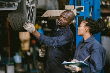 Wall Mural - Auto garage worker Black African working together to fix service car vahicle wheel support together