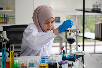 young muslim woman doing research in laboratory.