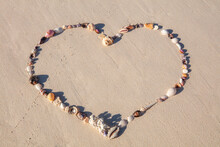 Shells In A Heart Shape In The Sand On The Beach
