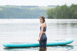 © deine_liebe - Beautiful slender girl doing yoga on a paddleboard. A young woman does water sports in the summer sunrise.