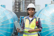 © amorn - Woman engineer or woman technician work at construction site area. Portrait of African American woman engineer worker standing near sewer pipes or water tank area at construction site