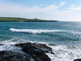 Fototapeta Morze - A sea on the south coast of Ireland near Clonakilty on a sunny day. Waves and coastal rocks under a clear blue sky. The beauty of Irish nature. Turquoise sea water, rock formation on sea