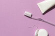 Dental care concept composition with toothbrush, tooth floss and toothpaste on the bright violet background. Copy space