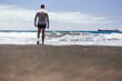 © Cavan - Beautiful young man enjoying and walking along black sand beach
