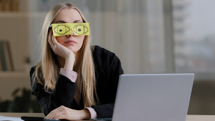 Lazy funny sleeping girl caucasian business woman tired sleepy female worker with sticky notes on eyes glasses with stickers sleeps in office feeling fatigued napping at workplace portrait