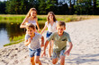 © Iryna - Happy different age kids running in nature, boys and girls play together in nature.