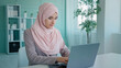 Sad shocked Arabian Indian Muslim Islamic looser businesswoman worker mistake in online document computer error close mouth with hand from failure reading bad news online frustrated losing problem