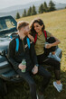Young couple relaxing on a terrain vehicle hood at countryside
