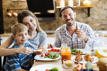 Wall Mural - Happy family  talking during lunch time at dining table