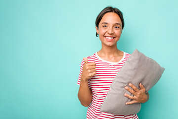 Wall Mural - Young hispanic woman holding a cushion isolated on white background smiling and raising thumb up