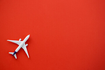 Wall Mural - Flat lay design of travel concept with plane on red background