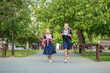 © Olha Tsiplyar - Two schoolgirls run to school with backpacks. Having fun. Concept back to school, learning