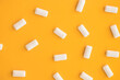 top view of heap of chewing gums on yellow background, copy space