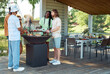 © Seventyfour - Full length portrait of friends enjoying barbecue whi9le partying outdoors in Summer, copy space
