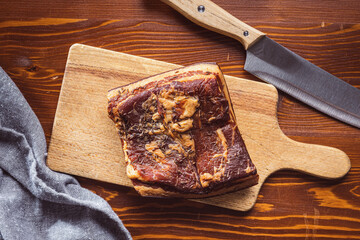 Canvas Print - Whole smoked bacon on cutting board.