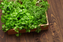A Top Of Bunch Of Green Dill, Parsley, Salad, Herbs And Other Greens In A Wooden Box, Dark Wood Background, Concept Of Fresh Vegetables And Healthy Food