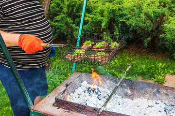 Wall Mural - Beef steaks with spices on a grill grill are fried on hot coals.