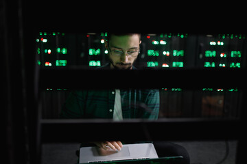Programmer processing data in own device in server room 