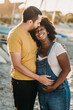 © Kelsey Smith/Stocksy - Maternity married couple at beach