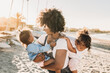 © Kelsey Smith/Stocksy - Mother and daughters at beach