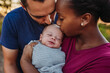 © Kelsey Smith/Stocksy - Parents Kissing Newborn
