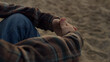 © stockbusters - Unrecognizable man sitting on sandy beach alone. Closeup guy clasped hands