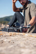 © Igor Kardasov/Stocksy - Bearded guy touching FPV drone on rocky mountain