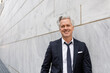 © McKinsey Jordan/Stocksy - Professional Man Smiles At Camera After Loosening His Tie After Work