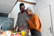 © Ezequiel Giménez/Stocksy - Happy black couple preparing dinner in kitchen