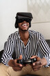 © Ezequiel Giménez/Stocksy - Excited African American gamer in VR goggles