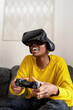 © Ezequiel Giménez/Stocksy - Happy African American woman playing VR videogame