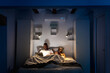 © Ezequiel Giménez/Stocksy - Black couple using devices in dark bedroom