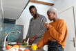 © Ezequiel Giménez/Stocksy - Trendy black couple preparing salad in kitchen