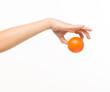 © serhii - female hands holding an orange sponge ball on a white background isolated