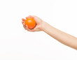 © serhii - female hands holding an orange sponge ball on a white background isolated