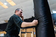 © Ezequiel Giménez/Stocksy - Determined martial artist punching bag in gym