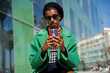 © Alba Vitta/Stocksy - Queer person taking selfie outside building