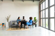 © Valentina Barreto/Stocksy - Business group relaxing on couch