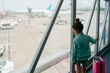 © Jimena Roquero/Stocksy - Kid on airport walkway with luggage waiting to board on plane