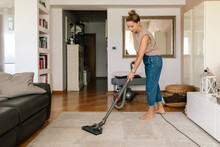 Woman Vacuuming The Carpet