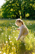 © Sergey Narevskih/Stocksy - Child picking flowers in field