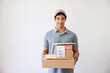 © ALTO IMAGES/Stocksy - Hispanic delivery man with stack of parcels