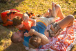 © Jelena Jojic Tomic/Stocksy - Kids play, wrestle, climb and annoy their father outdoors in a park