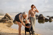 © Alba Vitta/Stocksy - Portrait of happy mother and adult daughter at the beach with dog
