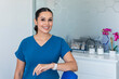 © Shava Cueva/Stocksy - A smiling female dentist in blue uniform in a dental clinic