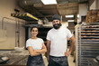 © Pedro Merino/Stocksy - Portrait of smiling artisan bakers in their business