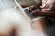 Crop woman using laptop on sofa